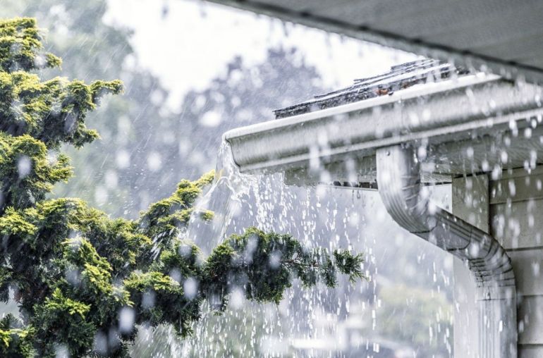 Gutter downspouts with pouring rain